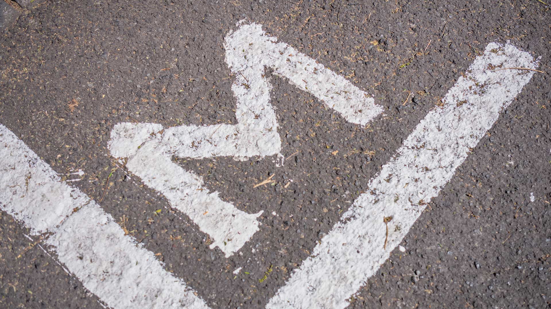 Road with white line painted and letter M marked on the asphalt.