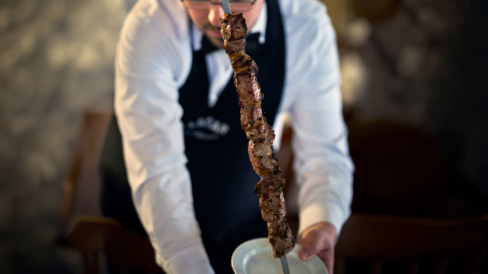 Person serviert eine Madeira-Espetada während einer Mahlzeit in einem Restaurant auf der Insel Madeira.