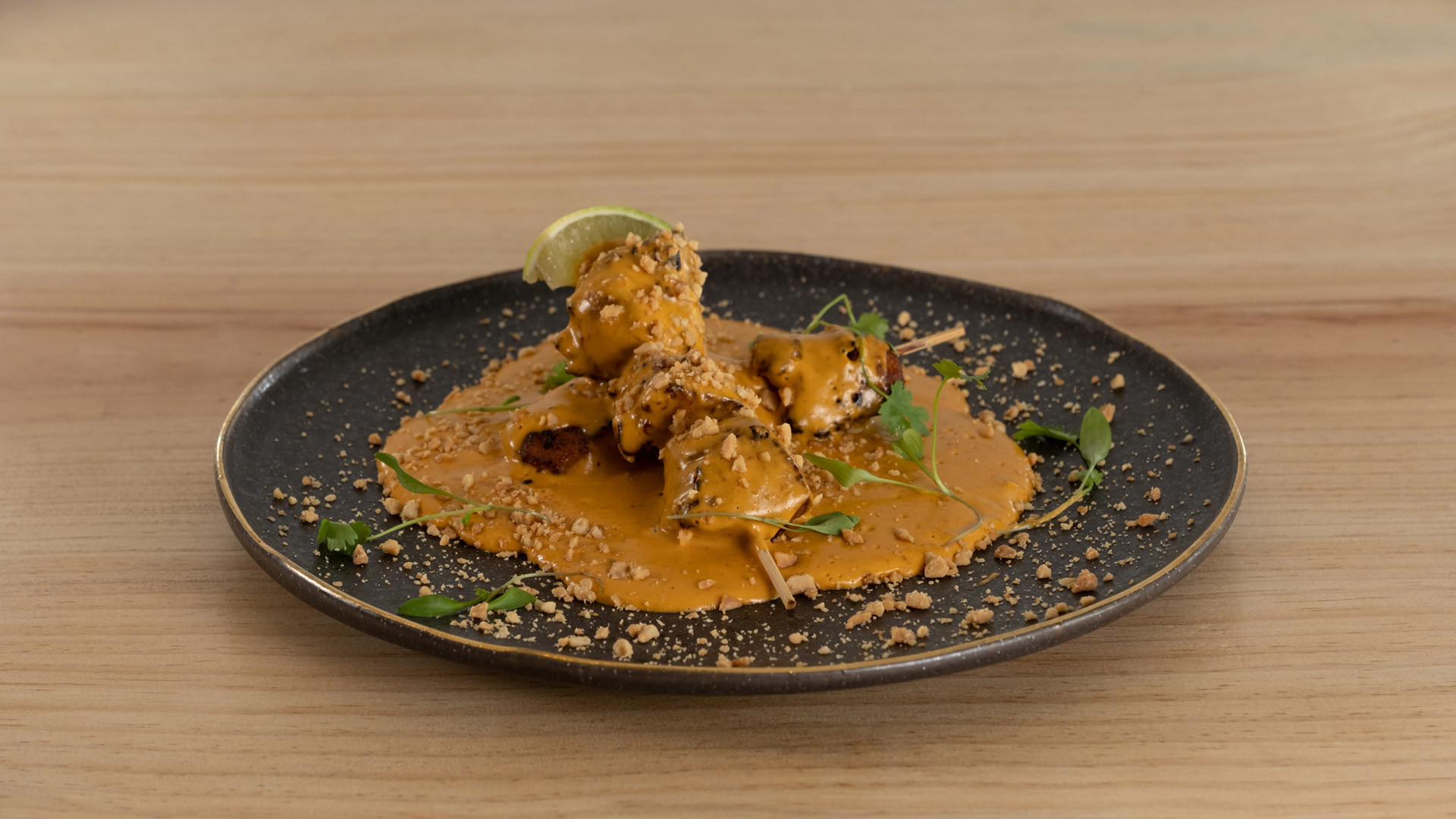 Plate with meat skewer served with sauce.