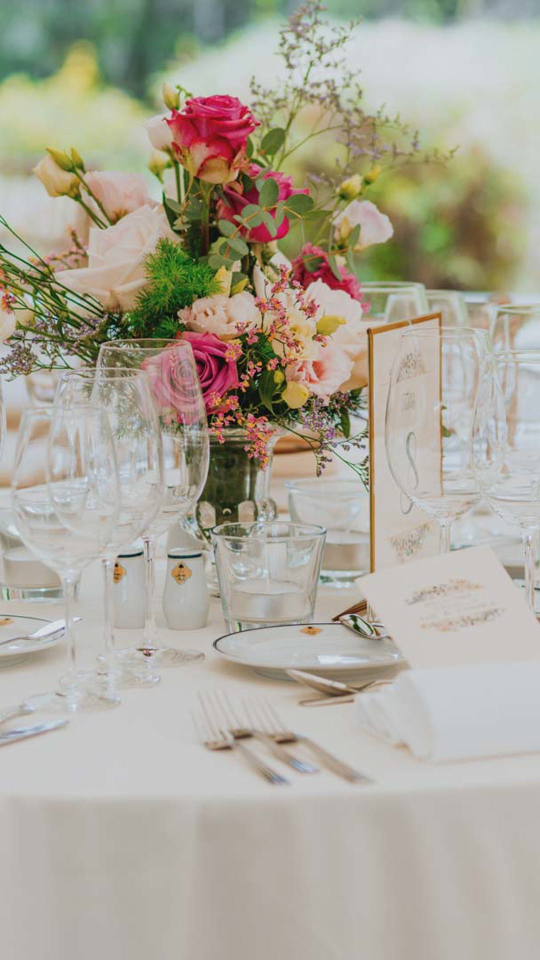 Mesa puesta decorada con elementos blancos y flores.