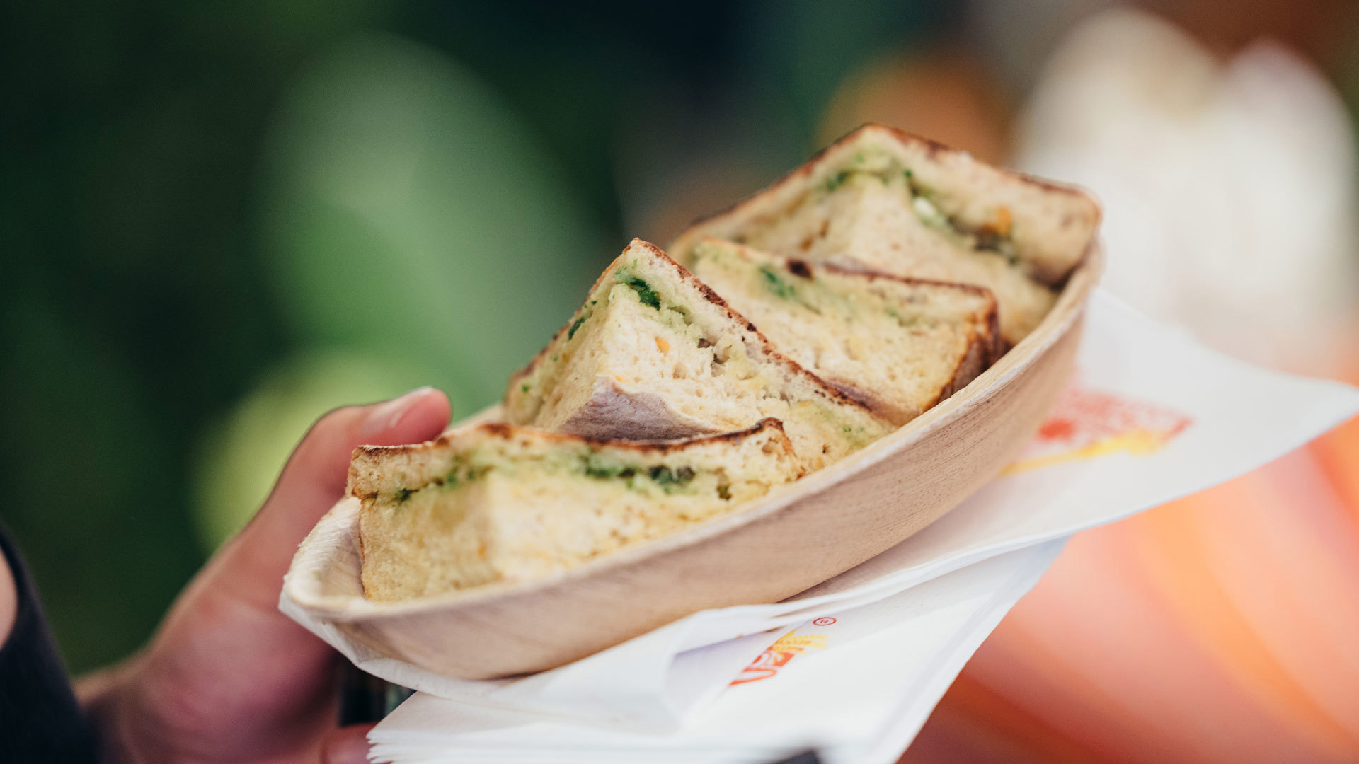 Bolo do caco with garlic butter served on a plate, held in hand.