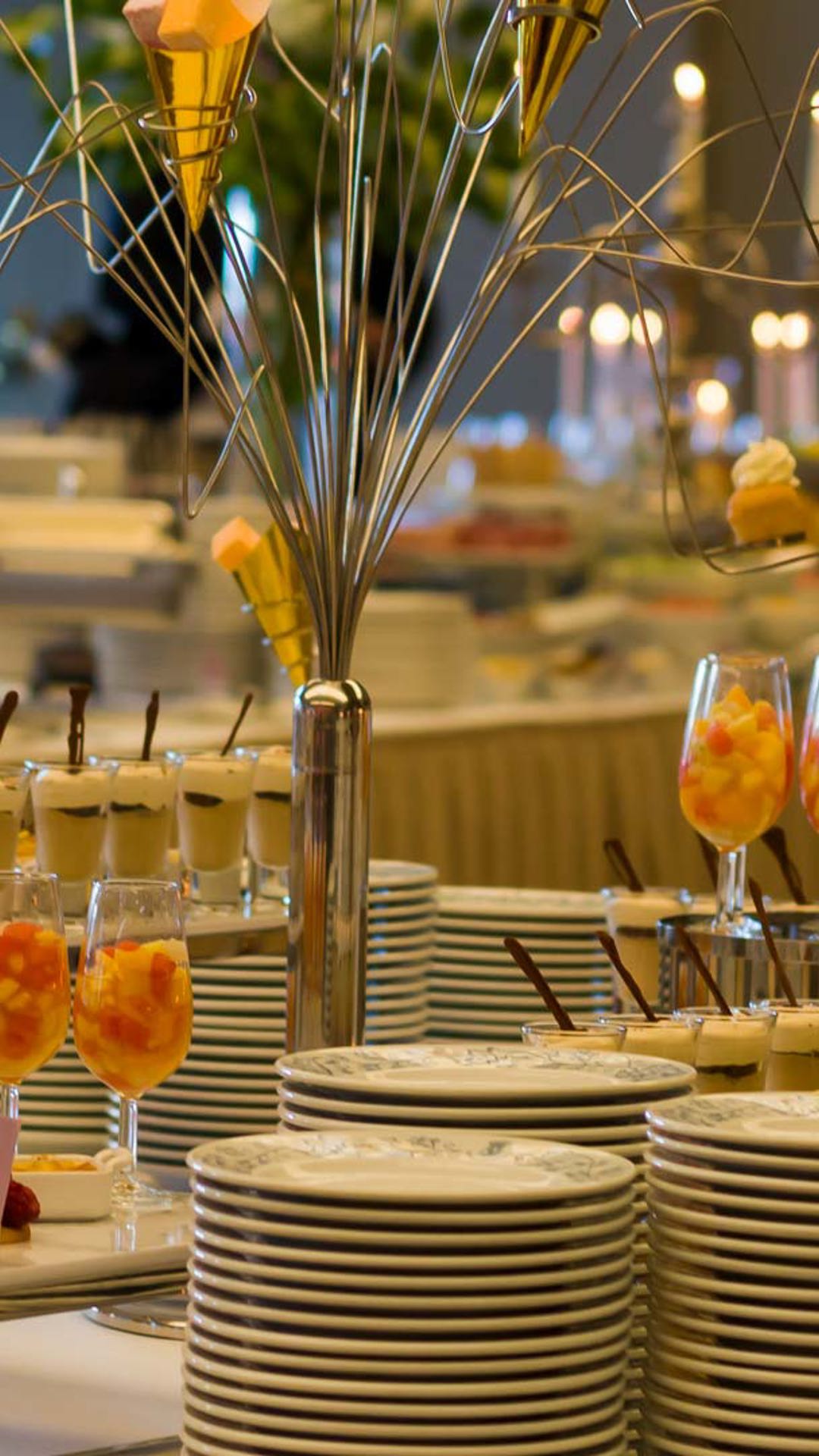 Pratos com opções de sobremesas numa mesa de buffet para cerimónia.