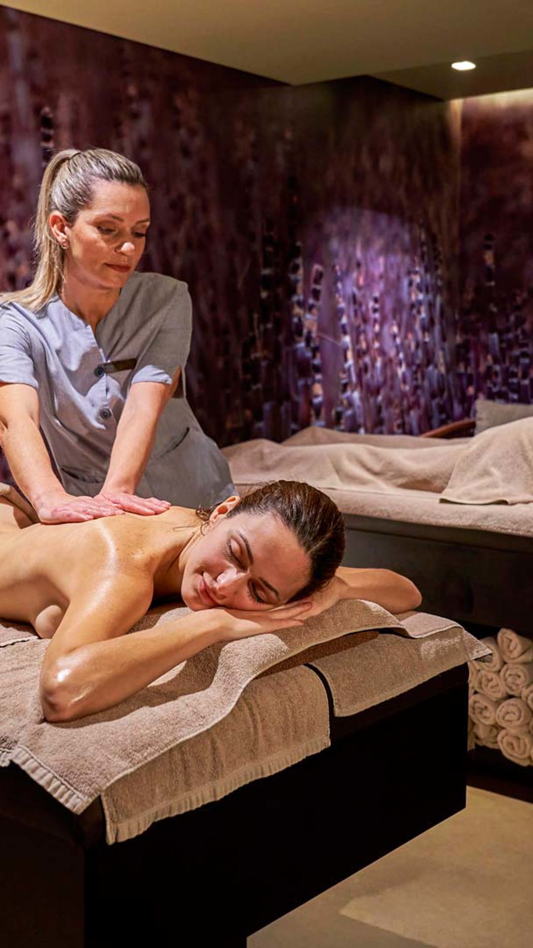 Two people receiving relaxation massages on massage tables.