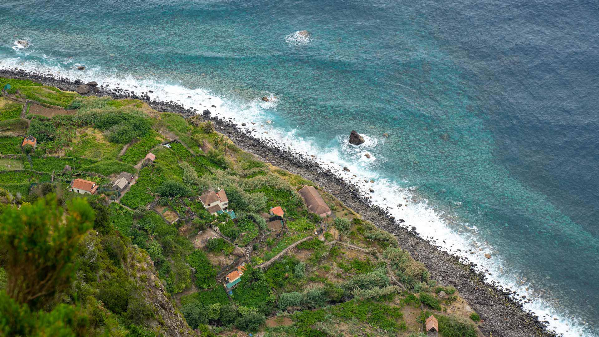 Terrenos verdes con casas junto a la playa de calhau y mar.