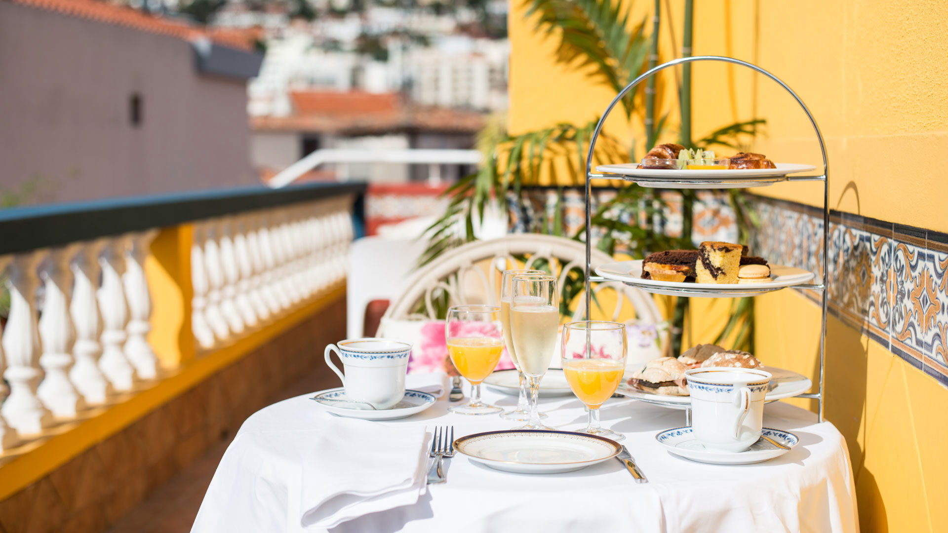 Table with plate, cutlery, food, and glasses of juice and water.