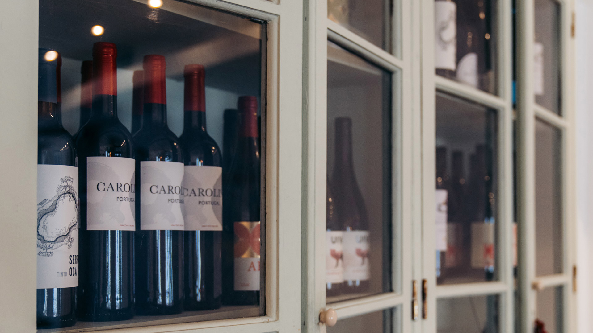 Cabinet with stored wine bottles.
