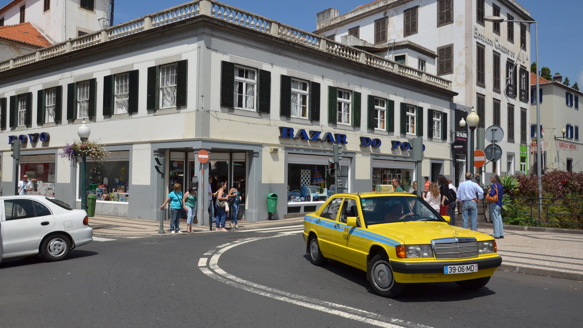 Yellow car on the road with people in Madeira.
