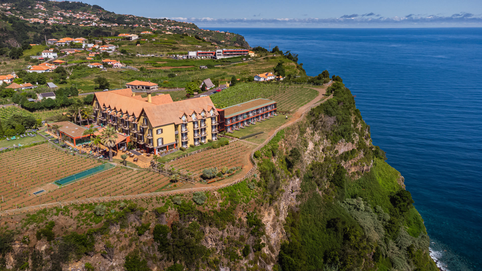 Yellow house with pool on land on the slope in Madeira.