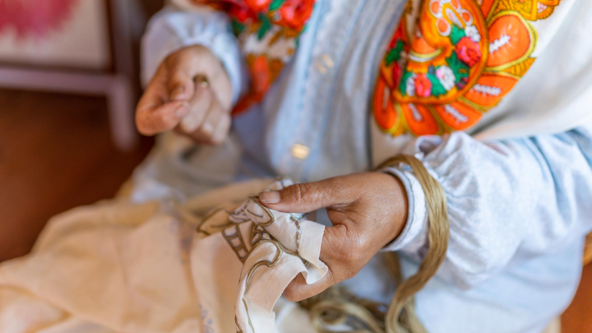 Embroiderer sewing embroidery by hand.