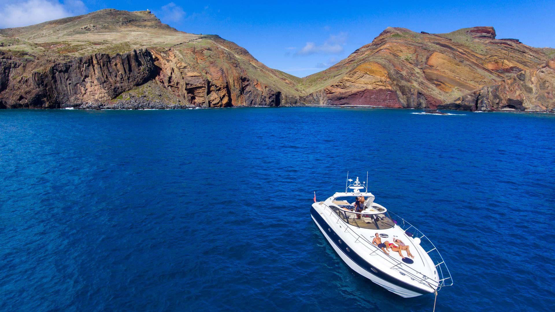 Boat at sea with the coastline in the background.
