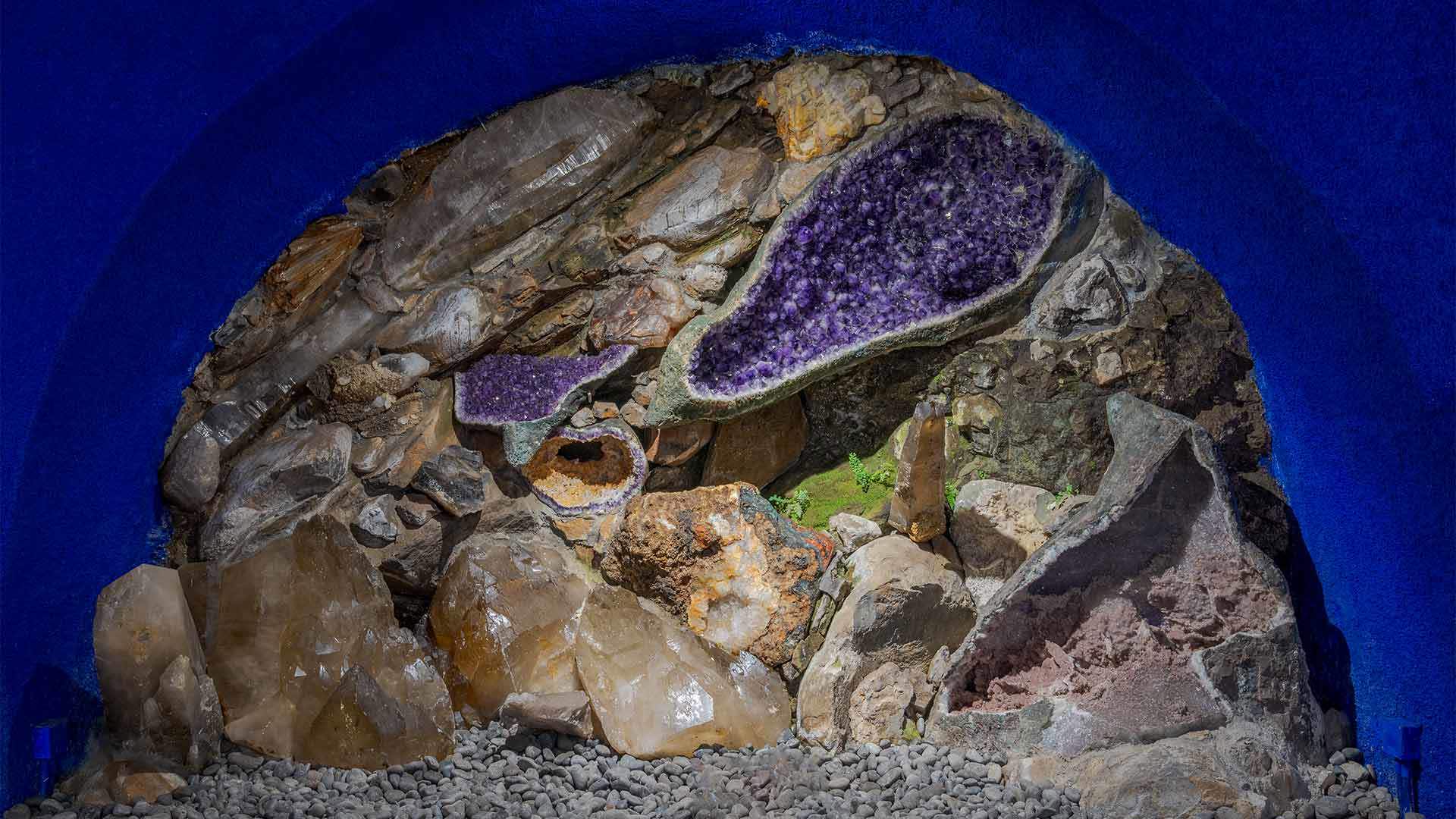 Exhibition of precious stones and minerals at Monte Palace Museum in a blue room.