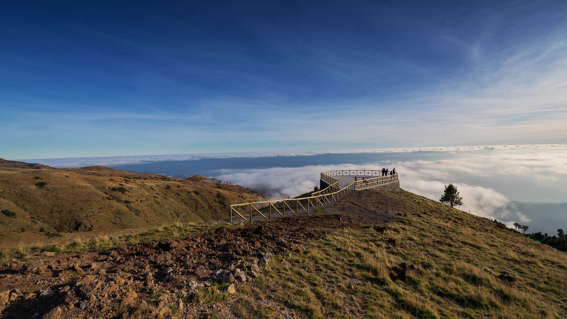 Aussichtspunkt Paredão mit Blick auf Funchal, Berge, Vegetation und blauen Himmel.