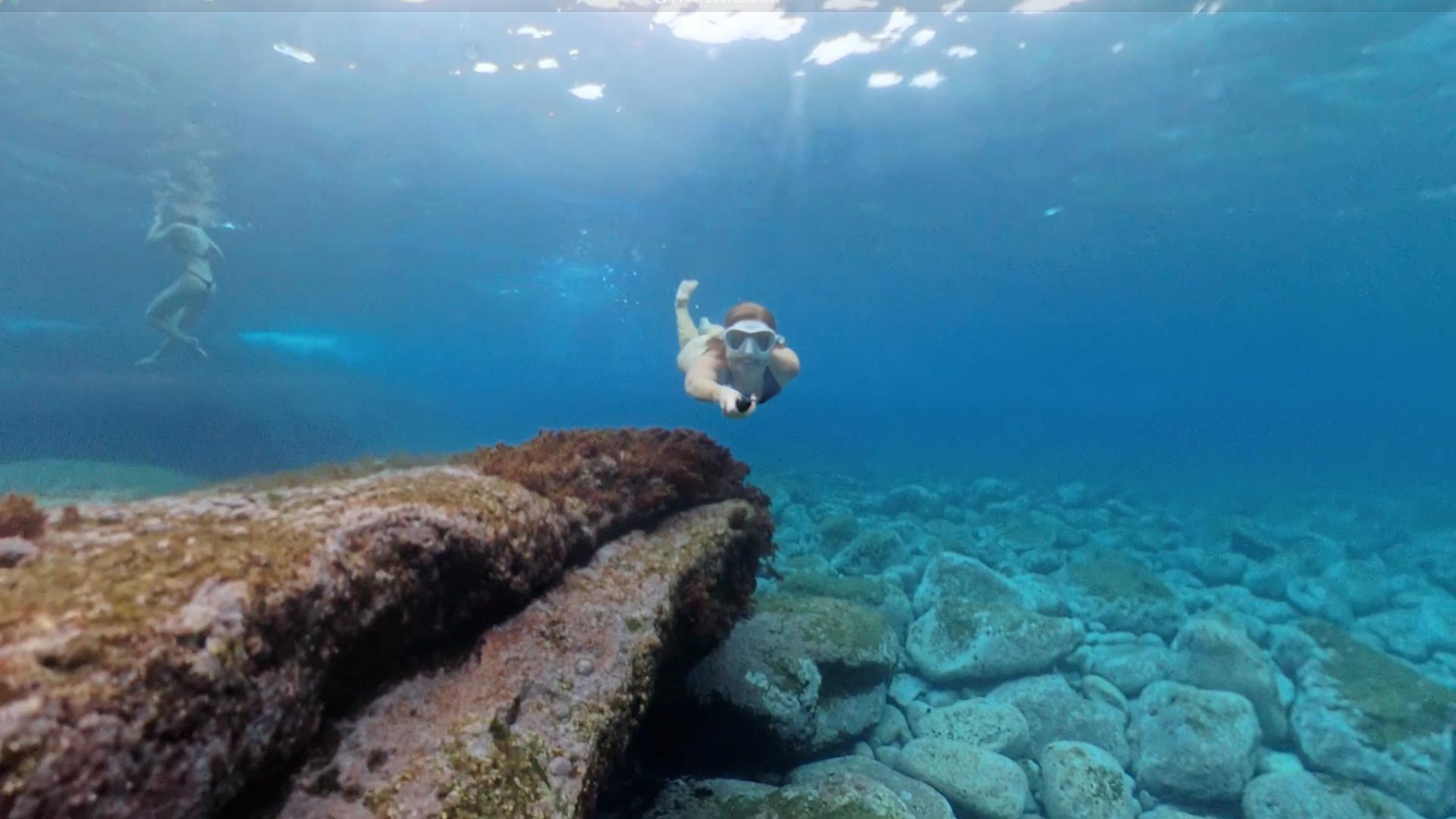 Frau beim Schnorcheln im Meer mit kompletter Ausrüstung.