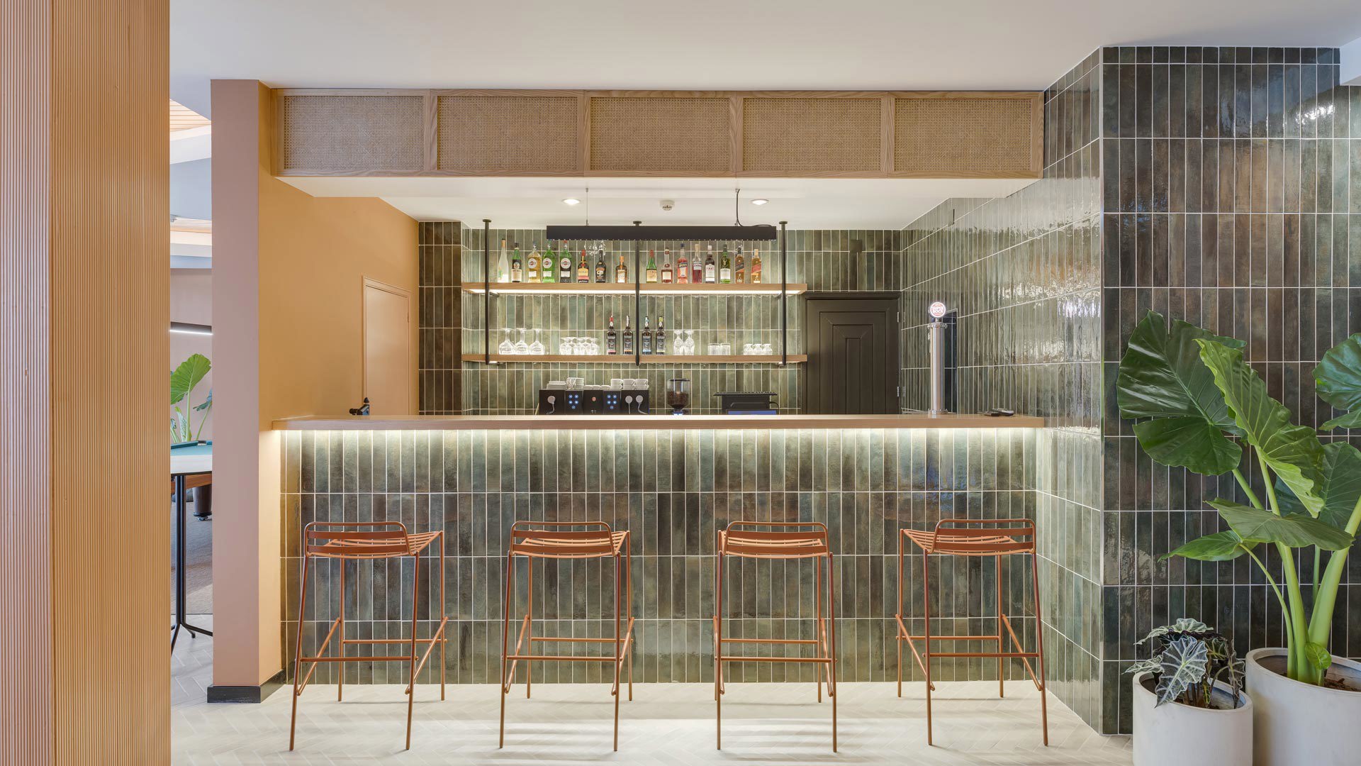Bar moderno no Editory Garden Carmo Funchal, com balcão e quatro cadeiras.