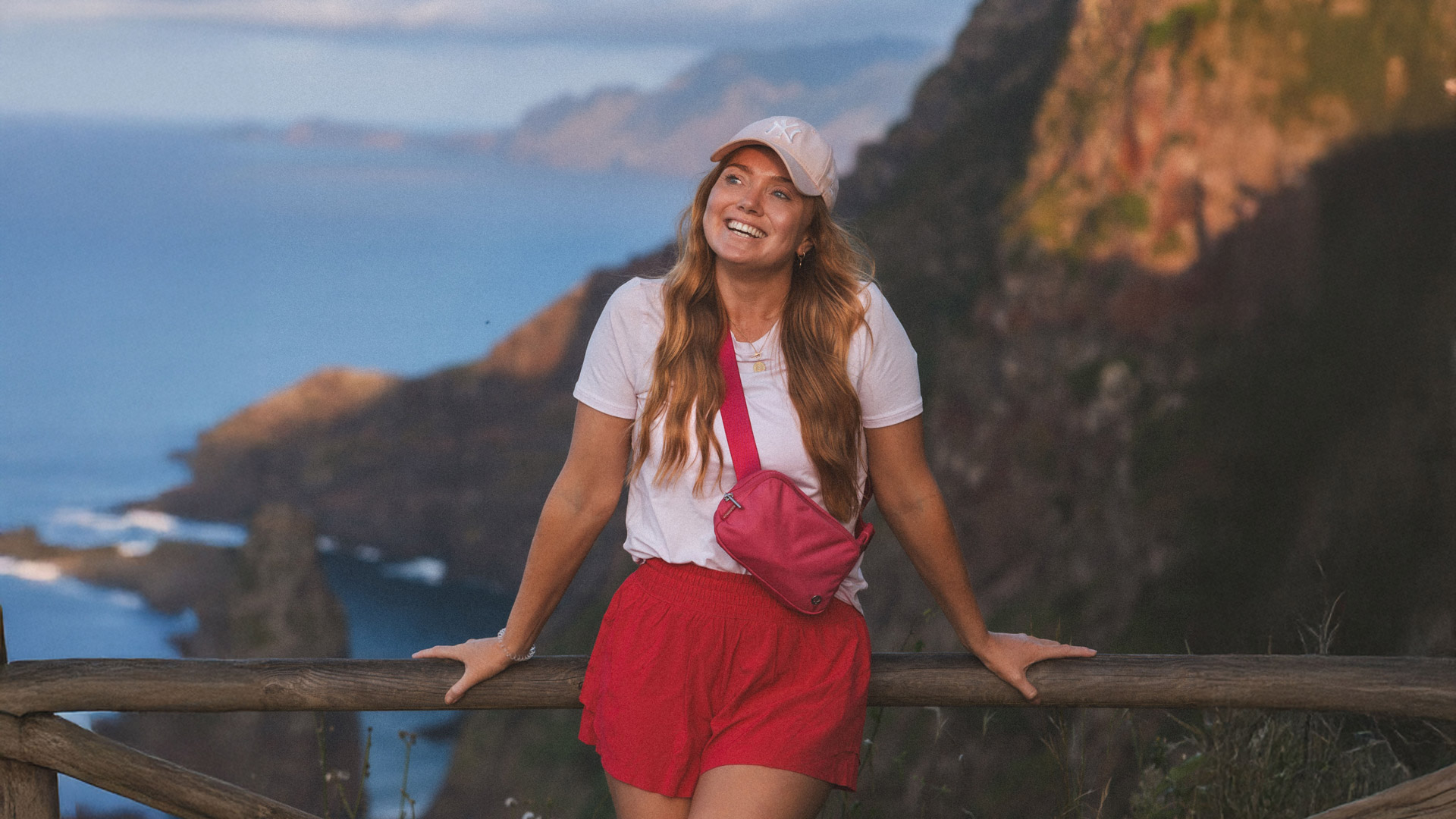 Frau genießt die Aussicht auf Rocha do Navio und trägt einen Hut.