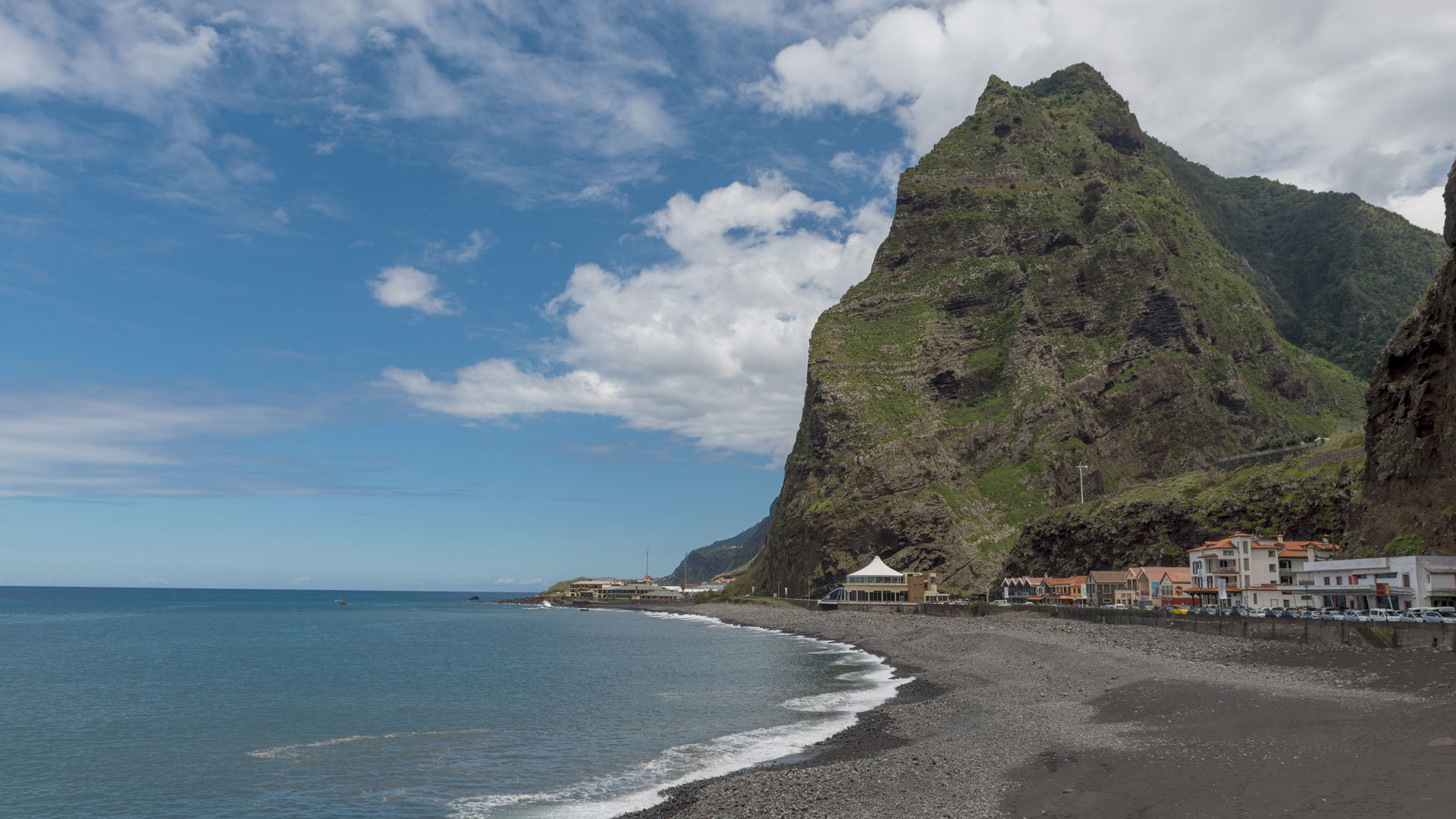 Strand neben dem Berg mit Himmel und Wolken auf Madeira.