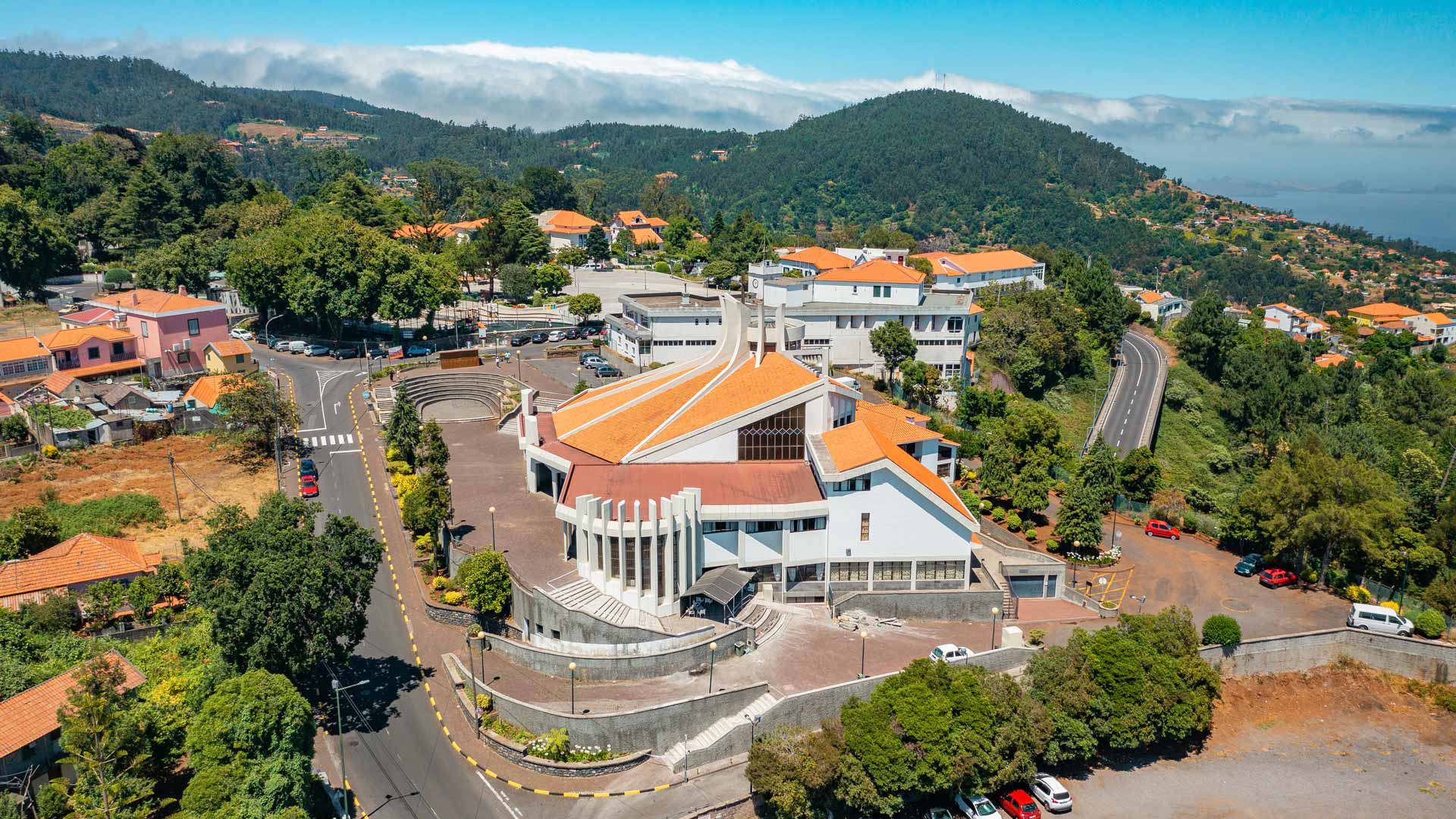 Kirchenäußeres in einem Dorf mit Berg im Hintergrund.  