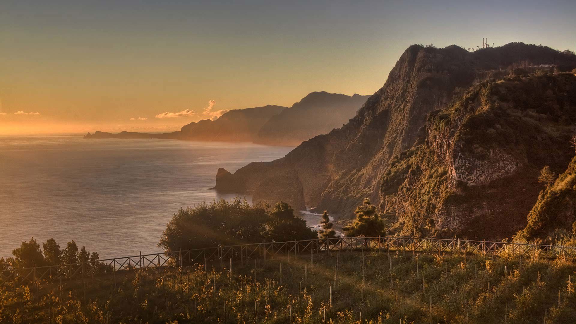 Sunset over fields with mountain and sea in Madeira.