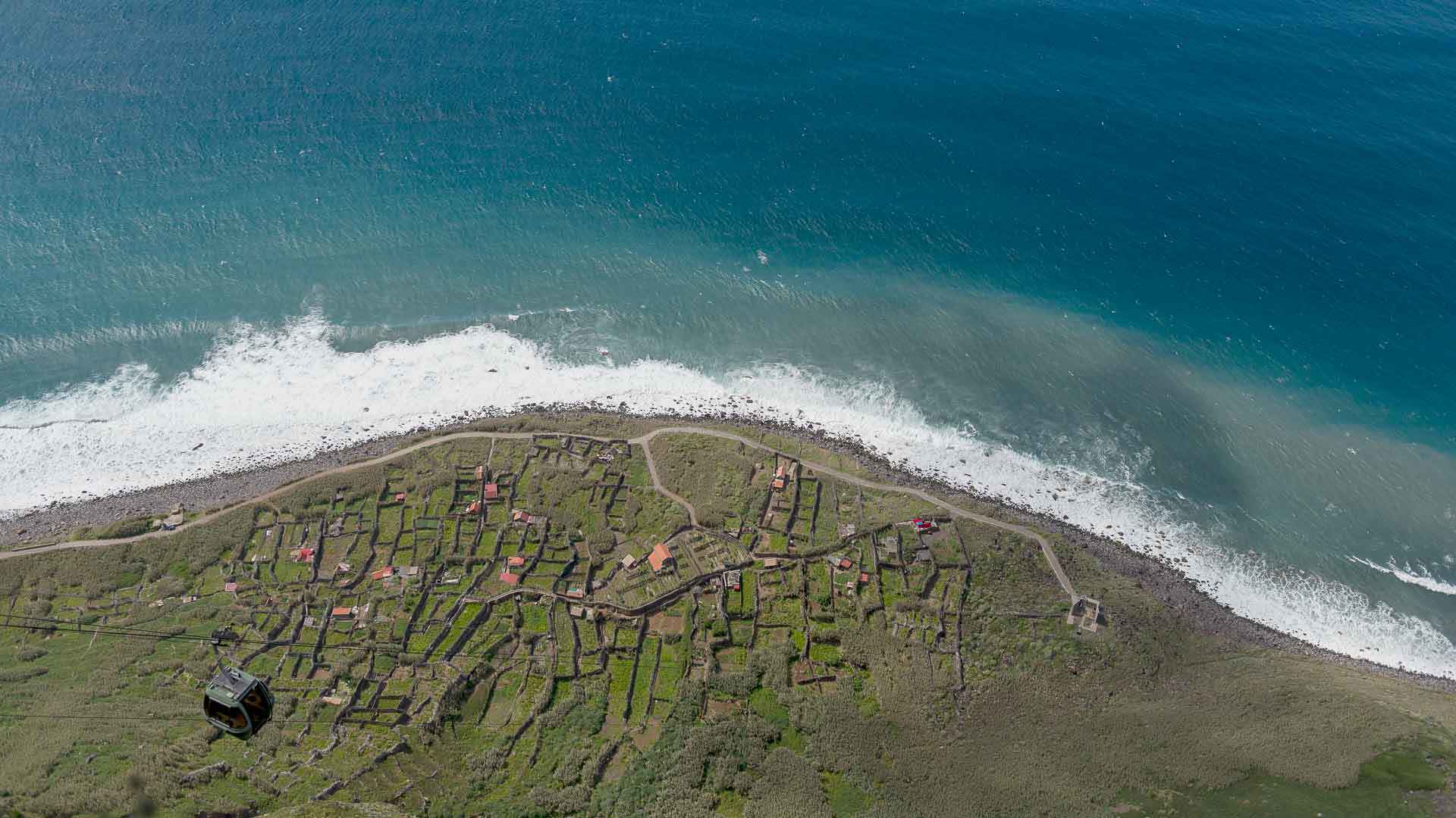 Seilbahn über Hang mit Blick auf das raue Meer auf Madeira.