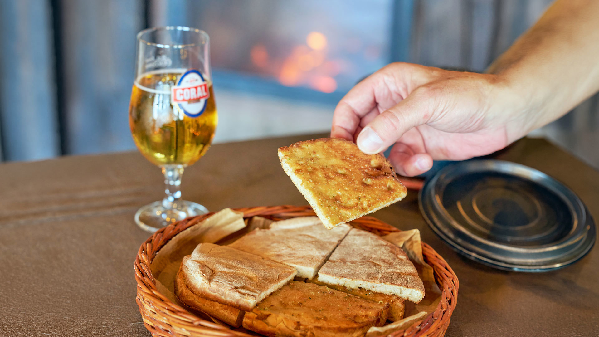 Bolo do caco with garlic butter accompanied by a beer.