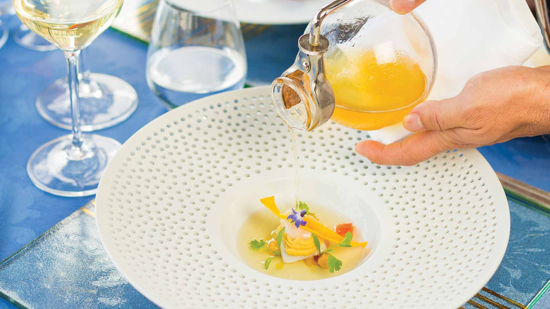 Assiette avec repas dressé et verres de vin sur la table, dans un style de cuisine contemporaine.