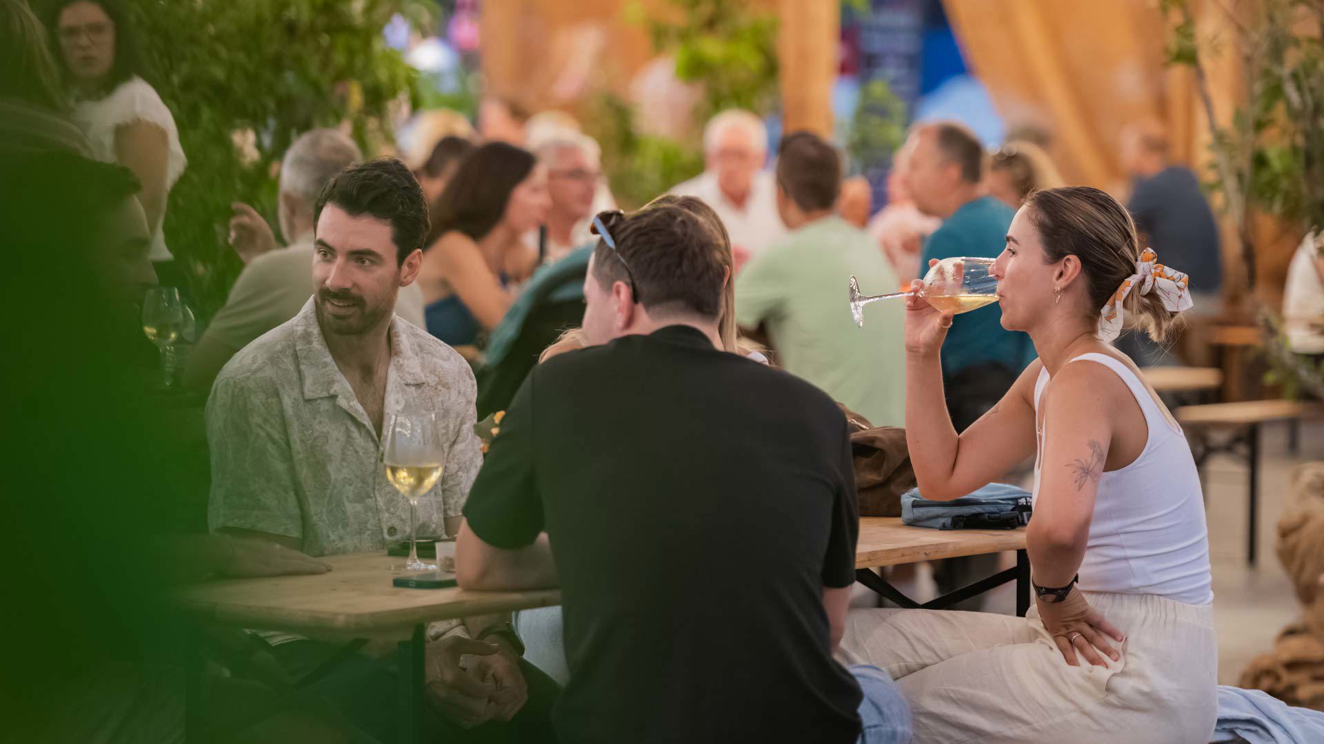 Amis partageant un moment au Wine Lounge lors de la Fête du Vin à table.