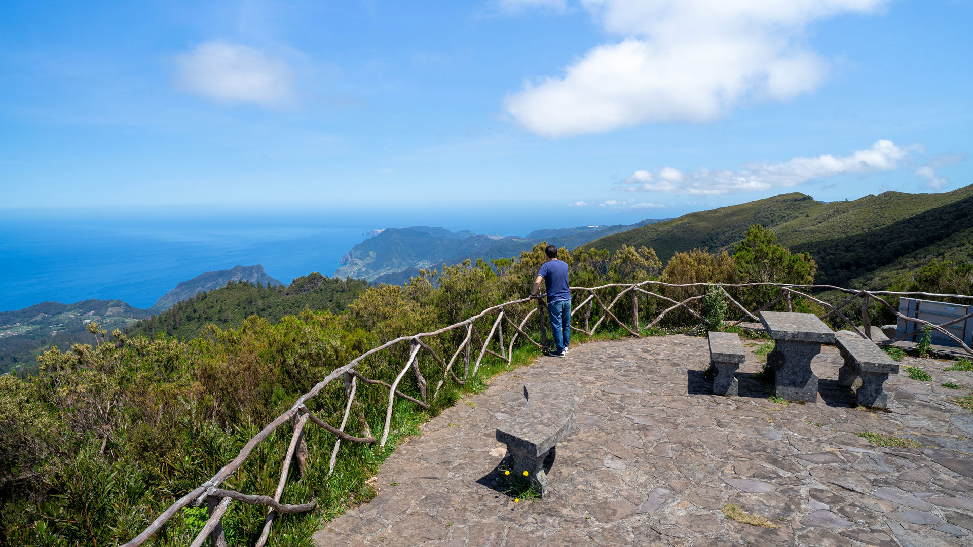 Aussichtspunkt mit Steinbänken und Blick auf Berge und Meer.