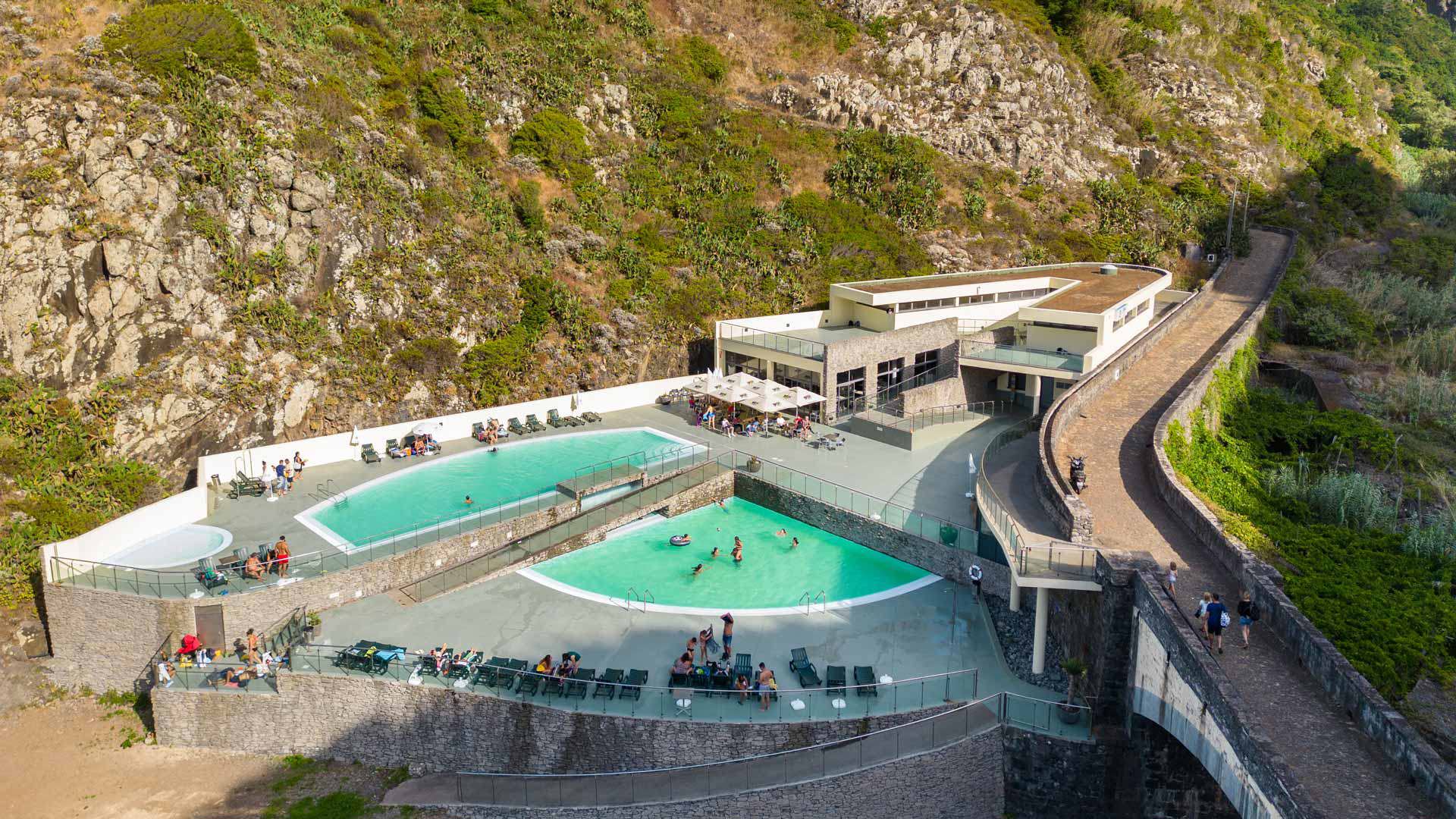 Personnes sur transats près de piscines proches des montagnes de Madère.
