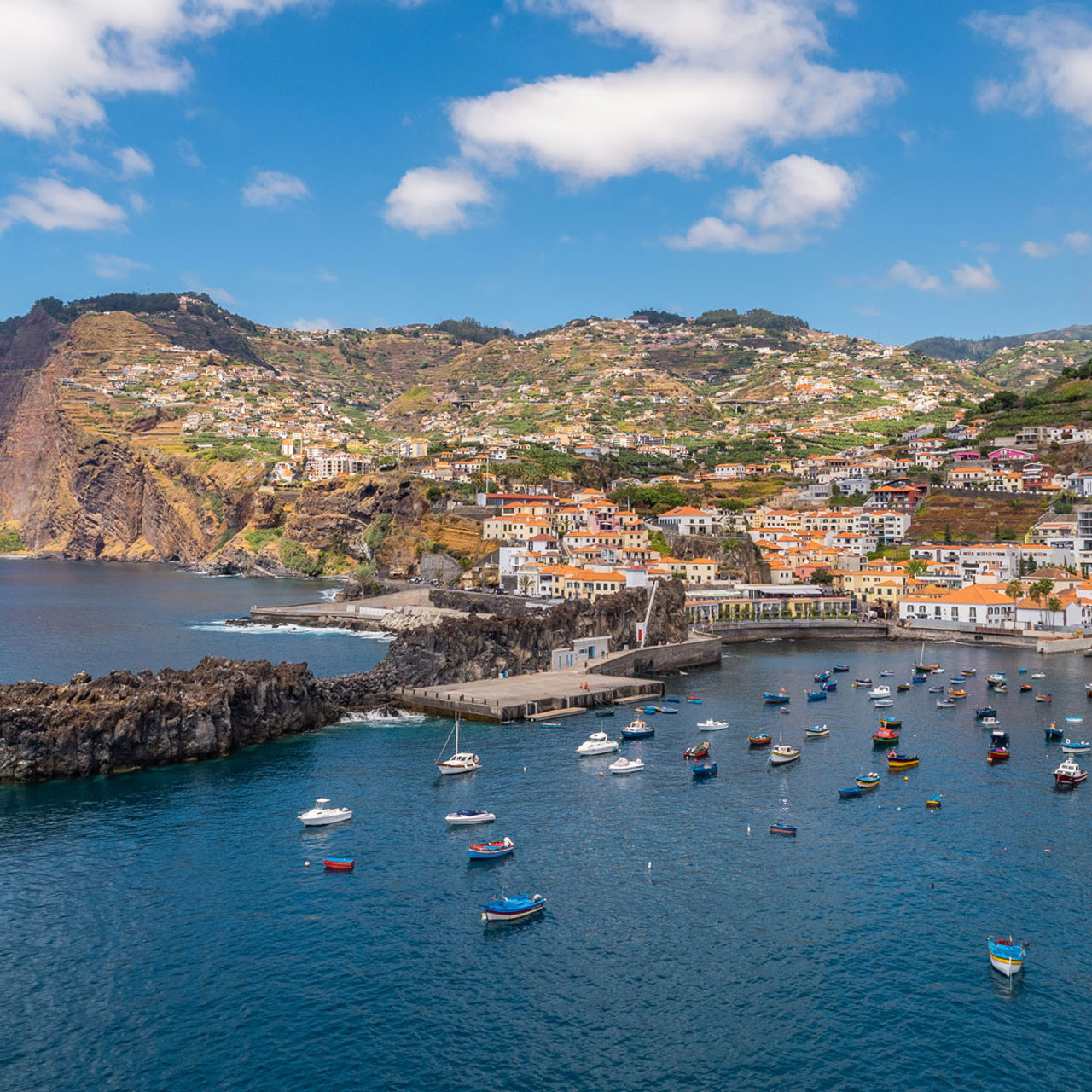 Câmara de Lobos Bay with calm sea and anchored boats.