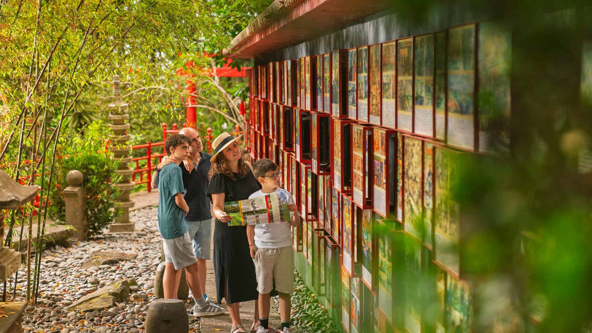 Famille observant une fresque lors de l’exposition extérieure au Jardin Tropical Monte Palace Madeira.