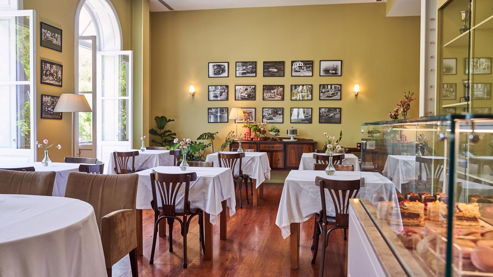 Espaço da Choux Pâtisserie com mesas e vitrine de bolos.
