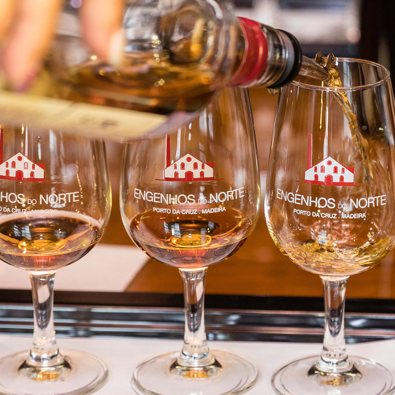 Vier Gläser Rum aus den Engenhos do Norte auf einer Oberfläche nebeneinander.