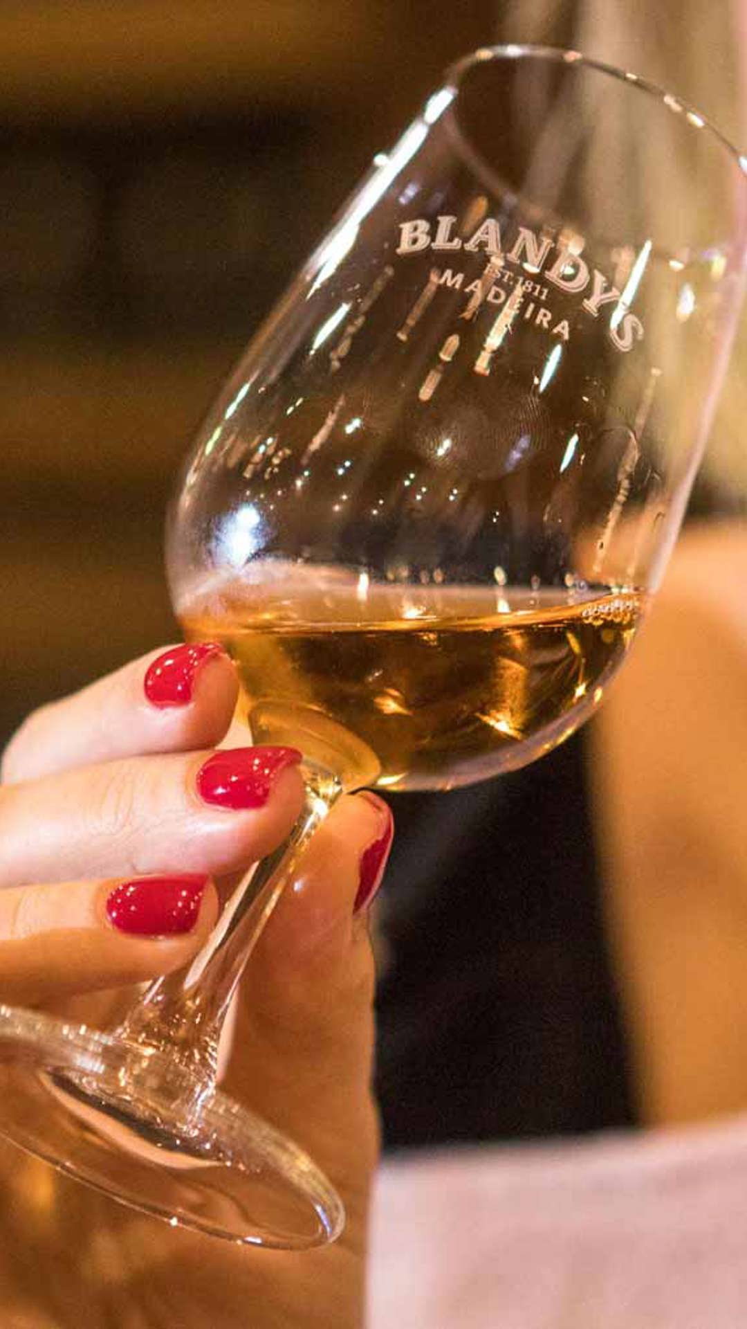 Woman tasting Madeira wine on Madeira Island.