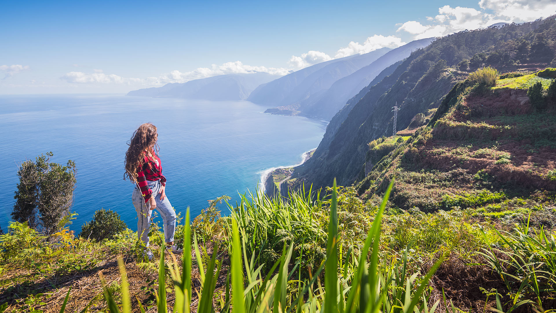 Frau am Aussichtspunkt, die die Aussicht auf Küste, Meer und Berg auf Madeira genießt.