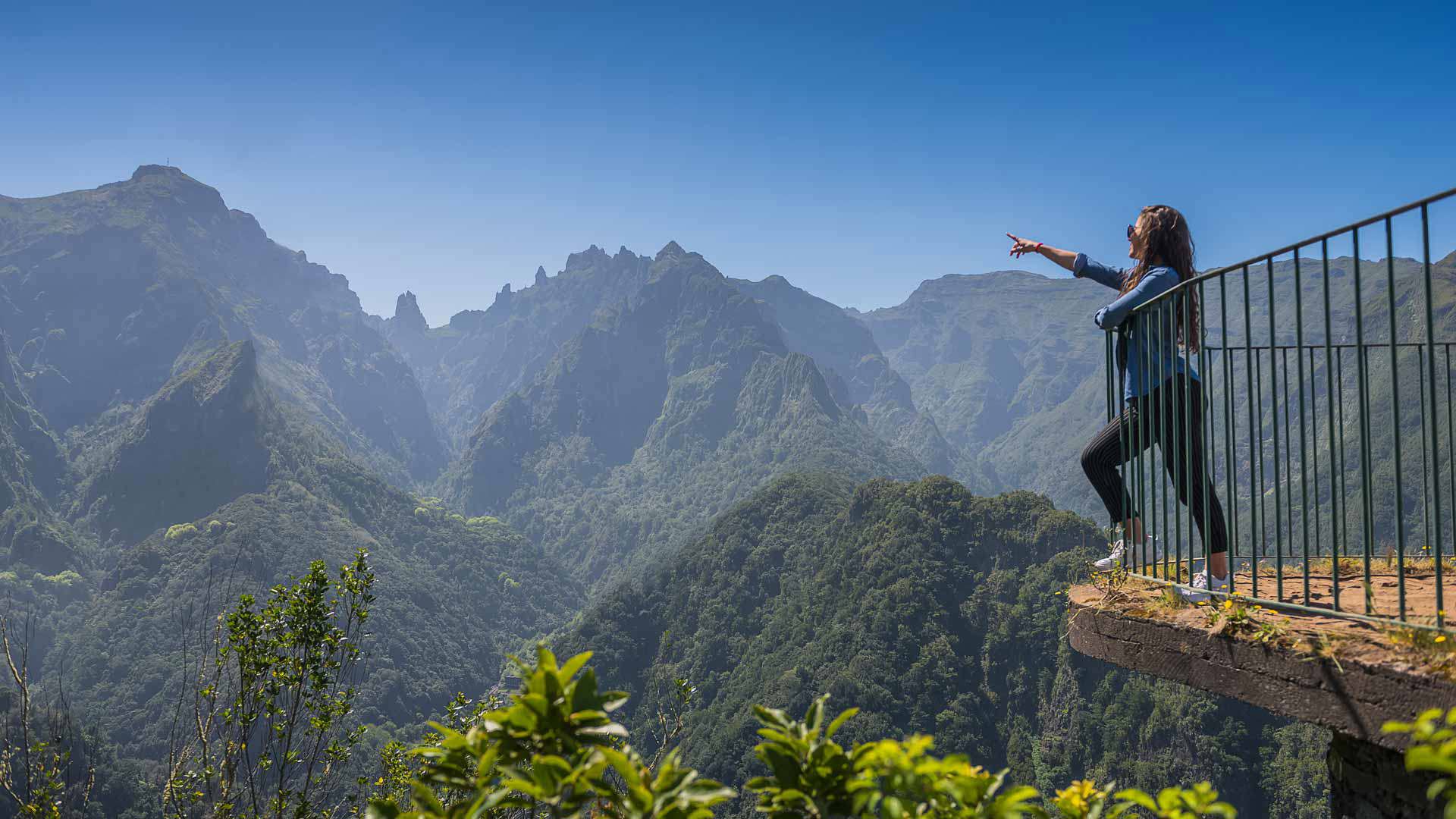 Persona señalando en el mirador con montañas en Madeira.