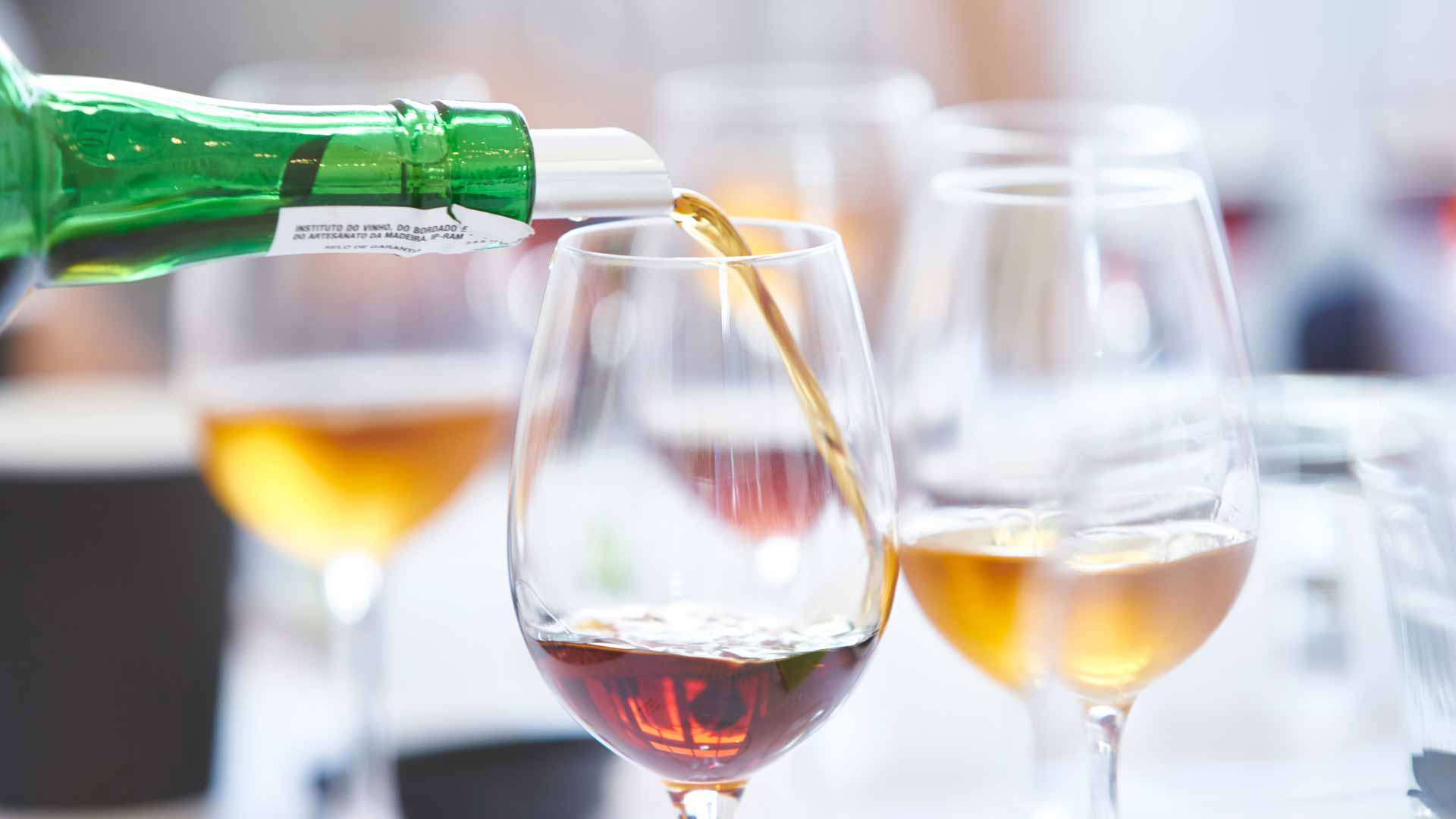 Botella sirviendo vino en copas durante una degustación de vino de Madeira, en la isla de Madeira.
